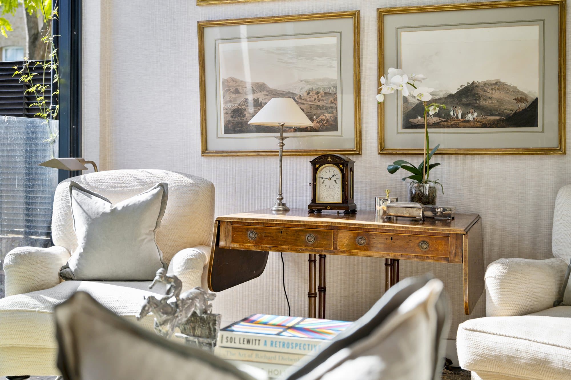 Armchair beneath framed artwork