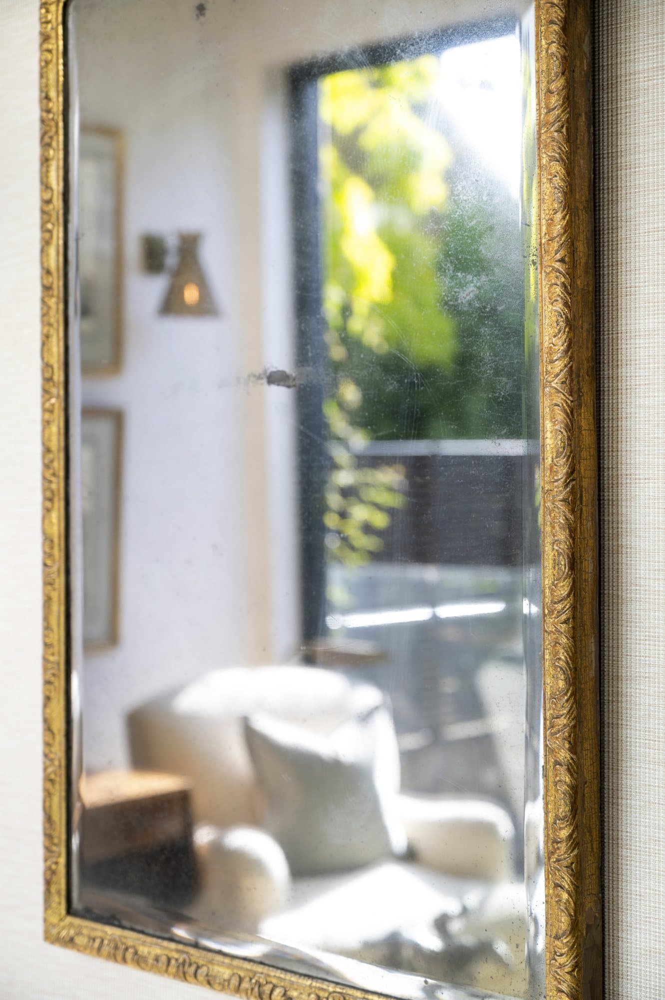 Gilt mirror reflecting the garden doors