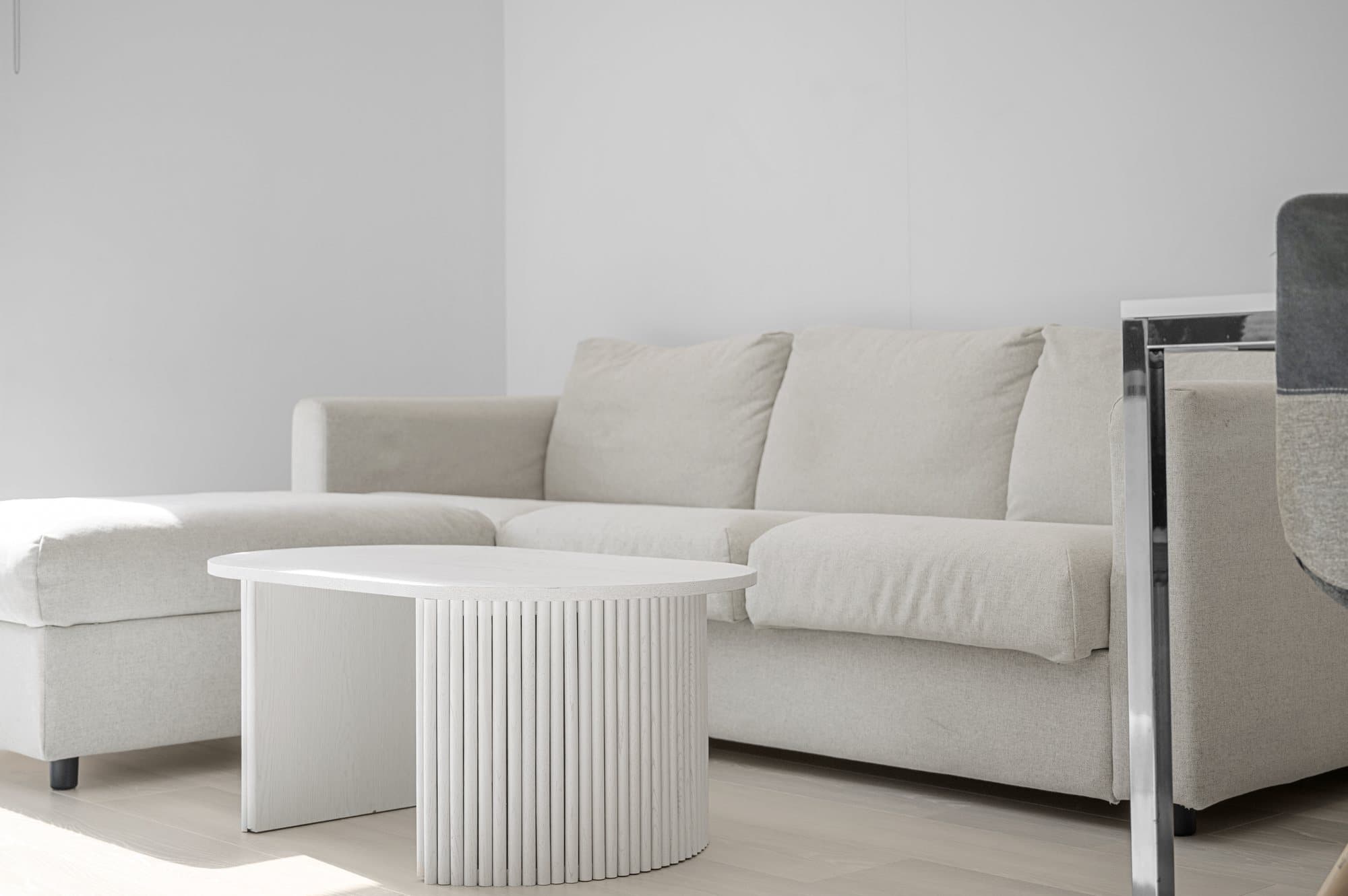 Pale sofa and fluted coffee table in a riverside apartment at Chelsea Bridge Wharf