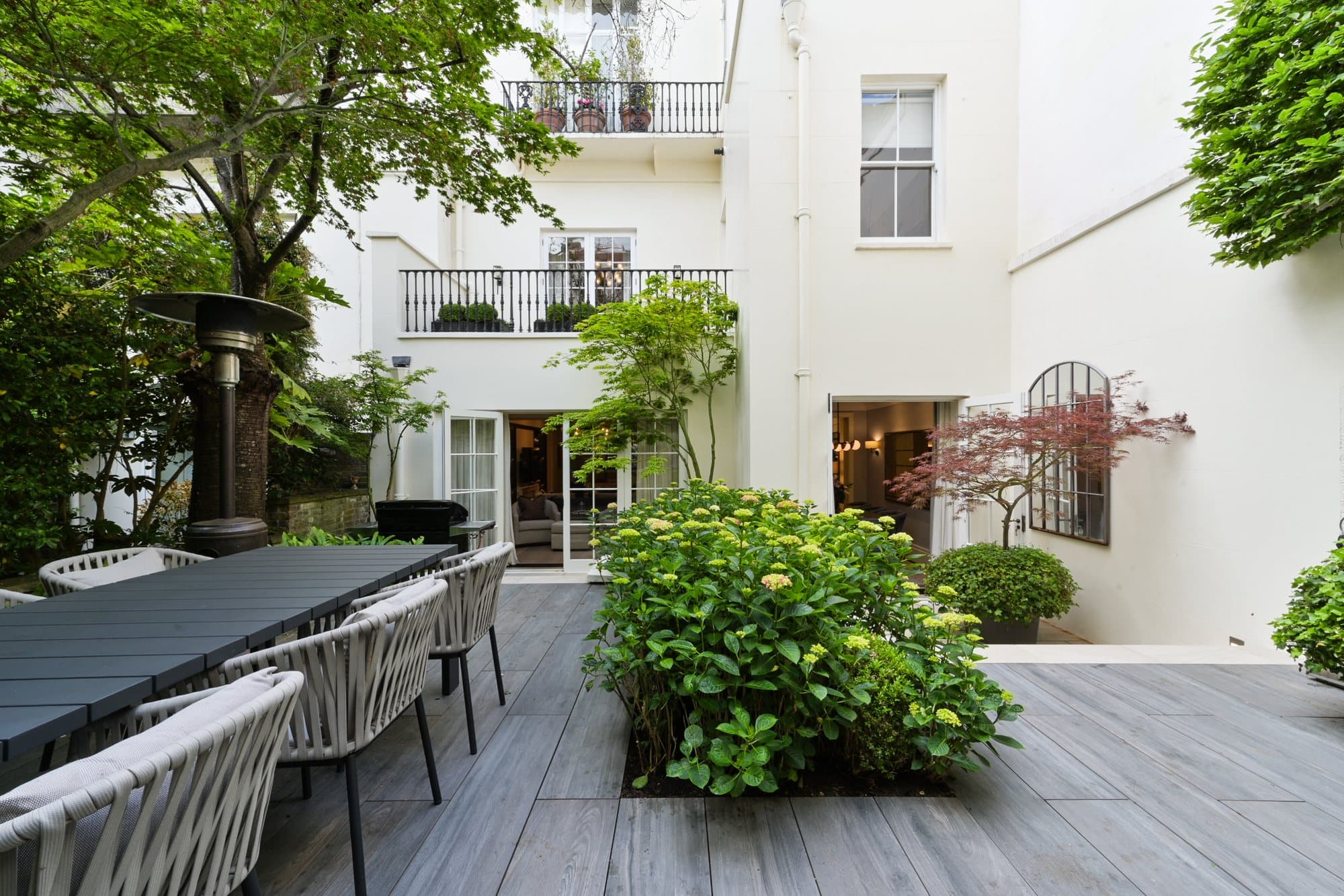 Courtyard laid for dining beneath a white facade