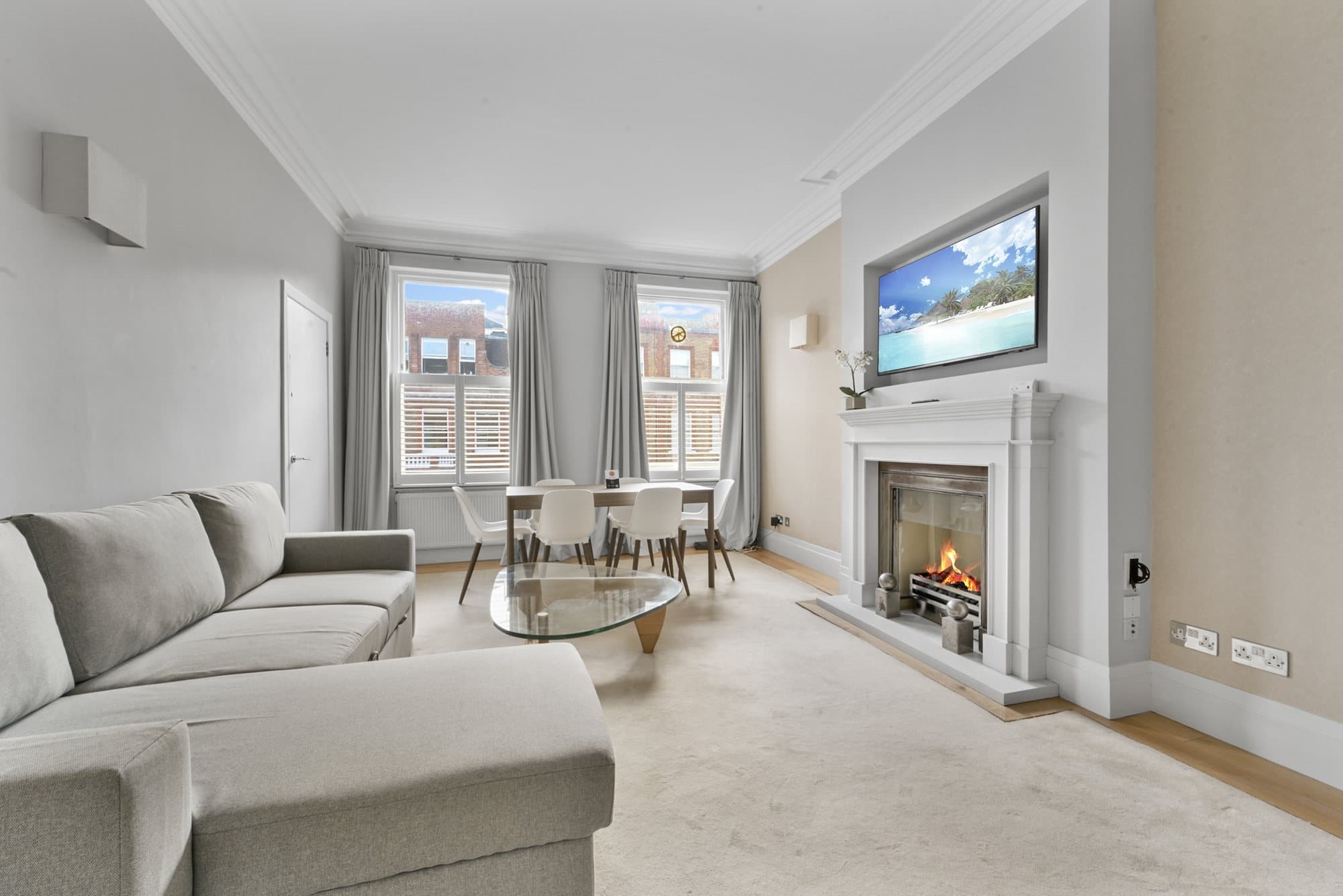 Stone fireplace with a lit fire in a South Kensington reception room