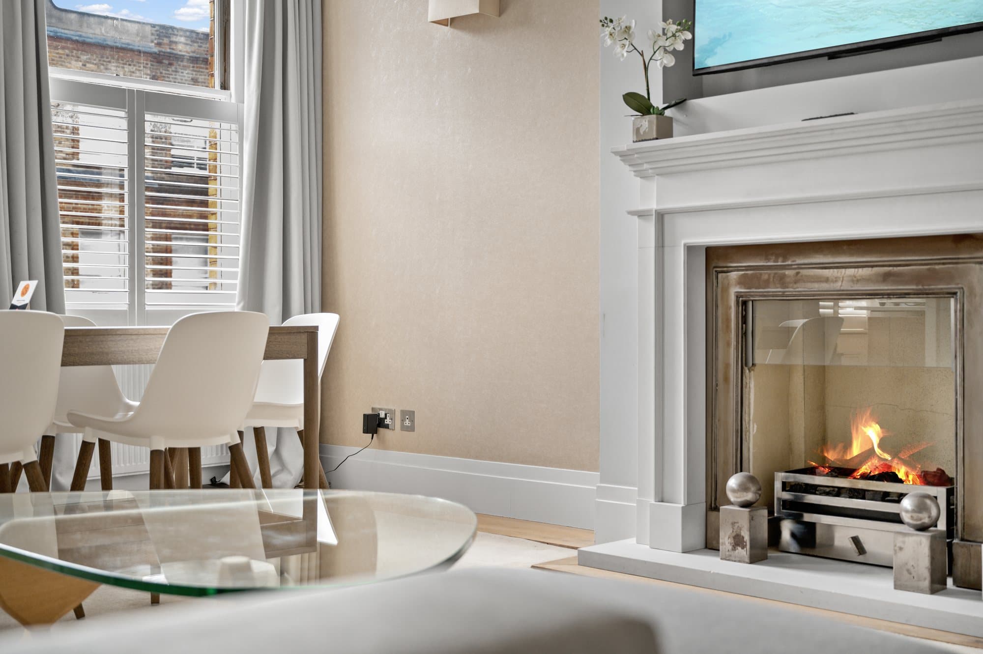 Stone fireplace with a lit fire in a South Kensington reception room